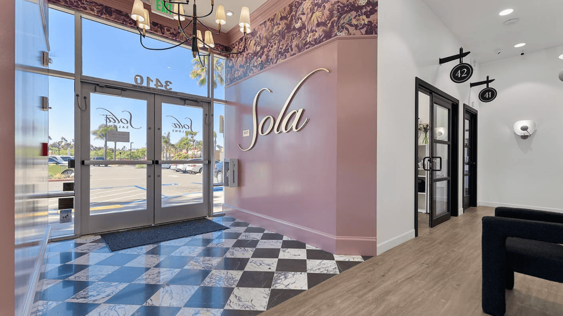 Photo of lobby of Sola Salons location with pink wall and floral wallpaper