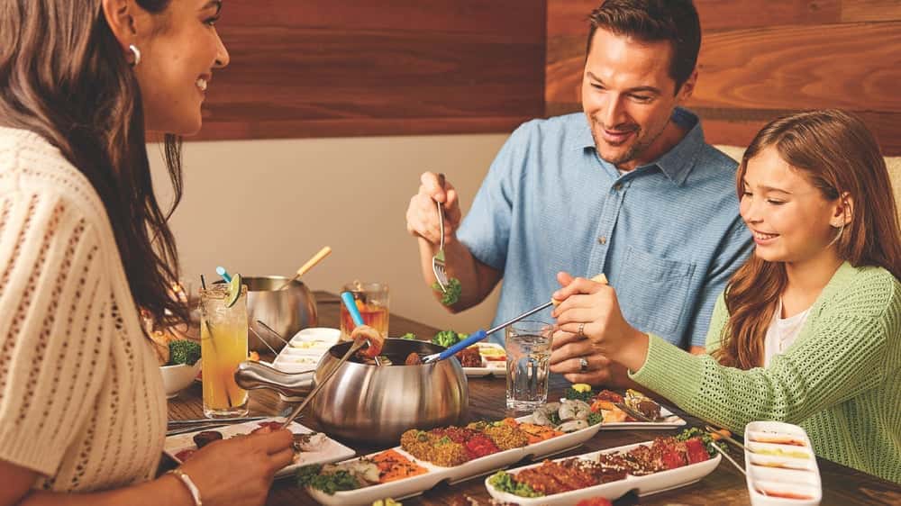 Melting Pot Owns the Experiential Dining Model in family enjoying The Melting Pot