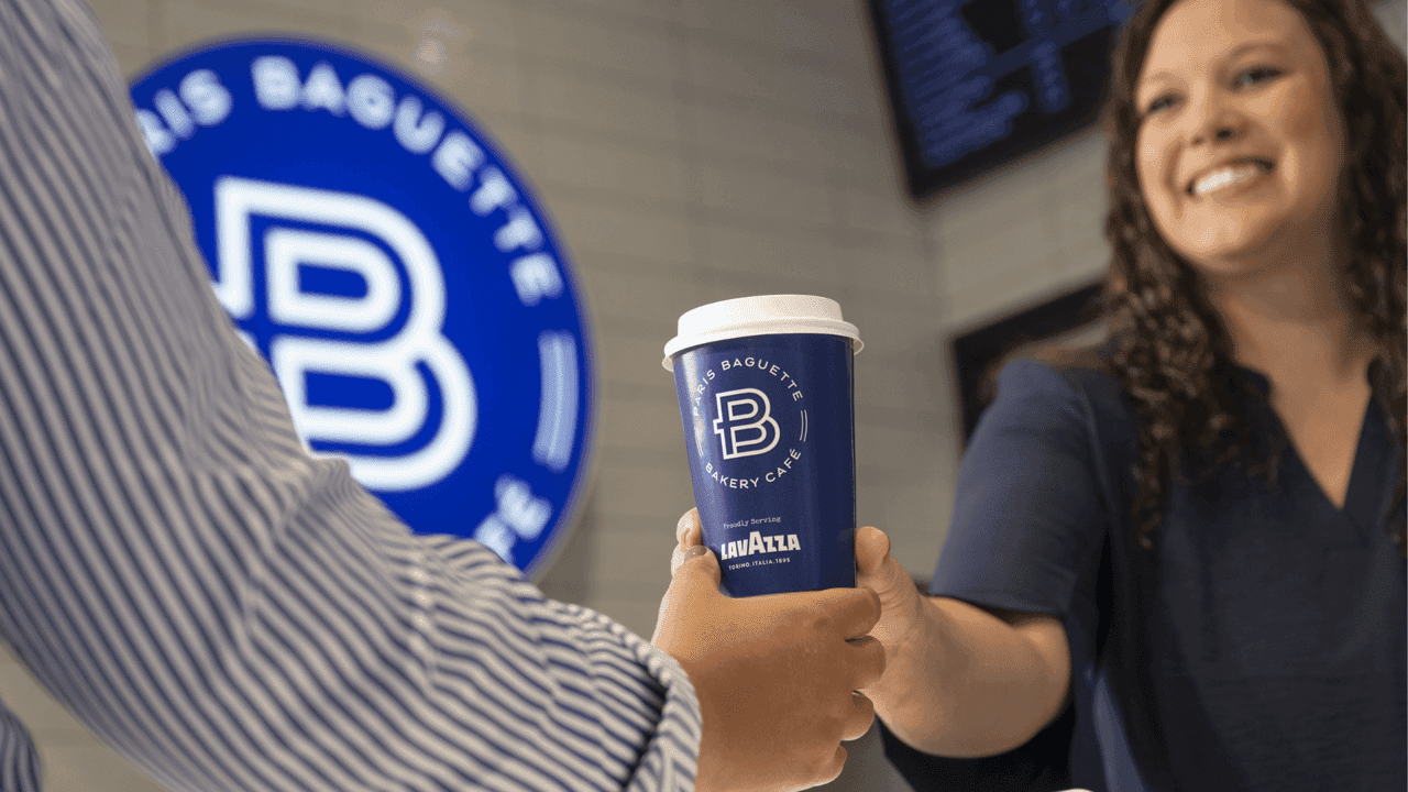 How undefined Evolved and Set New Standards Photo of person handing blue Paris Baguette coffee cup to guest