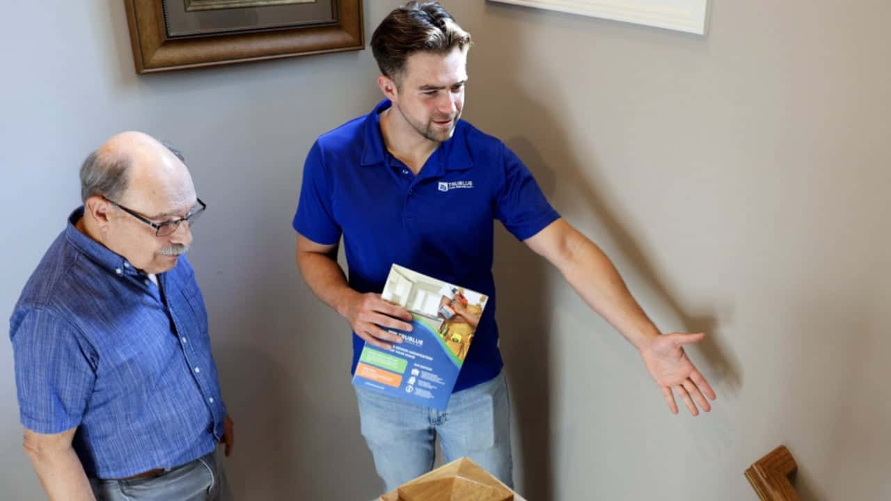 How undefined Evolved and Set New Standards image of trublue franchise owner showing an elderly customer a brochure