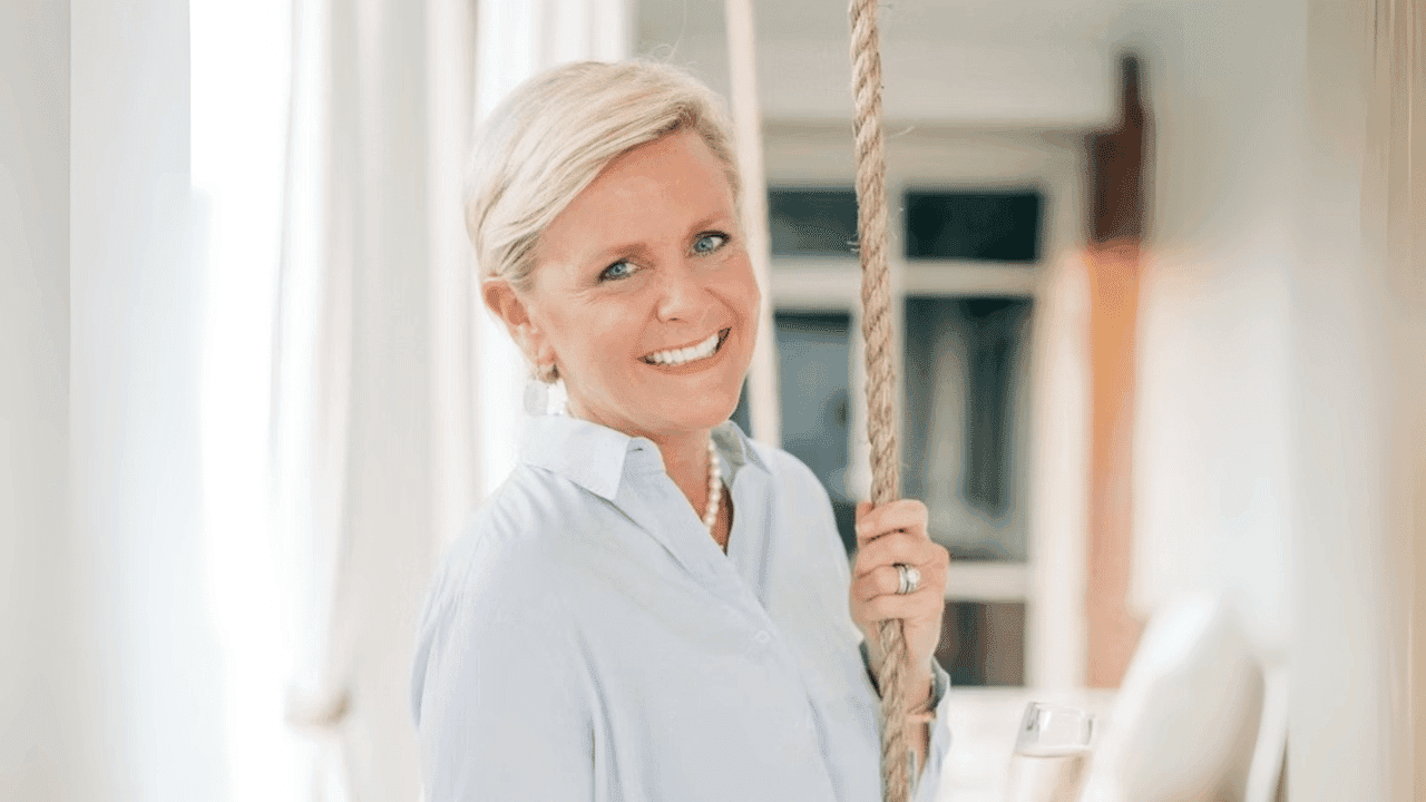 From Spa Guest to Multi-Unit Owner: Kimberly Powell’s photo of Woodhouse Spas franchisee Kimberly Powell smiling at the camera, wearing a light blue shirt