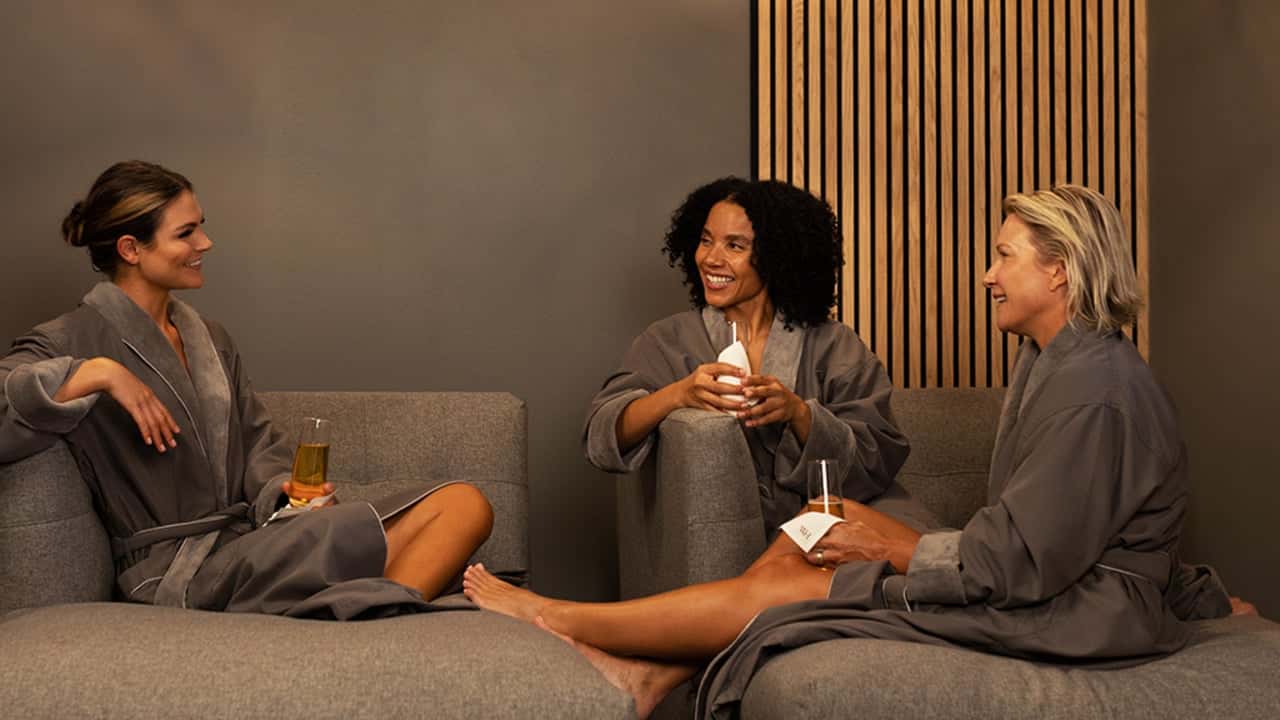 How undefined Evolved and Set New Standards Photo of three women in Woodhouse Spa room, wearing robes and holding beverages