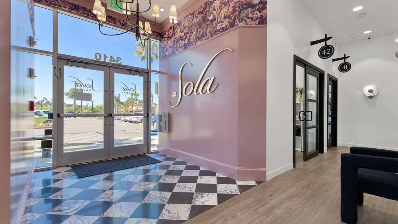 Sola Salons Recognized in Entrepreneur’s 2026 Franchise Photo of lobby of Sola Salons location with pink wall and floral wallpaper