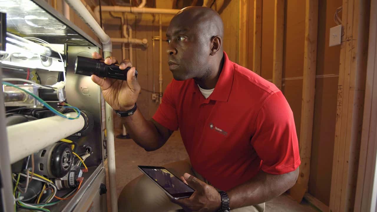 HomeTeam Inspection Service’s Strategic Technology Photo of HomeTeam inspector carrying flashlight and tablet