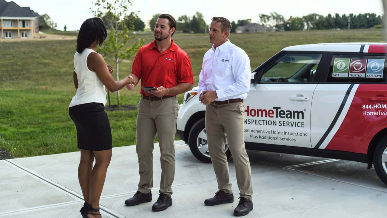 How HomeTeam Inspection Service Evolved and Set New Standards Photo of HomeTeam Inspection Service team speaking with client