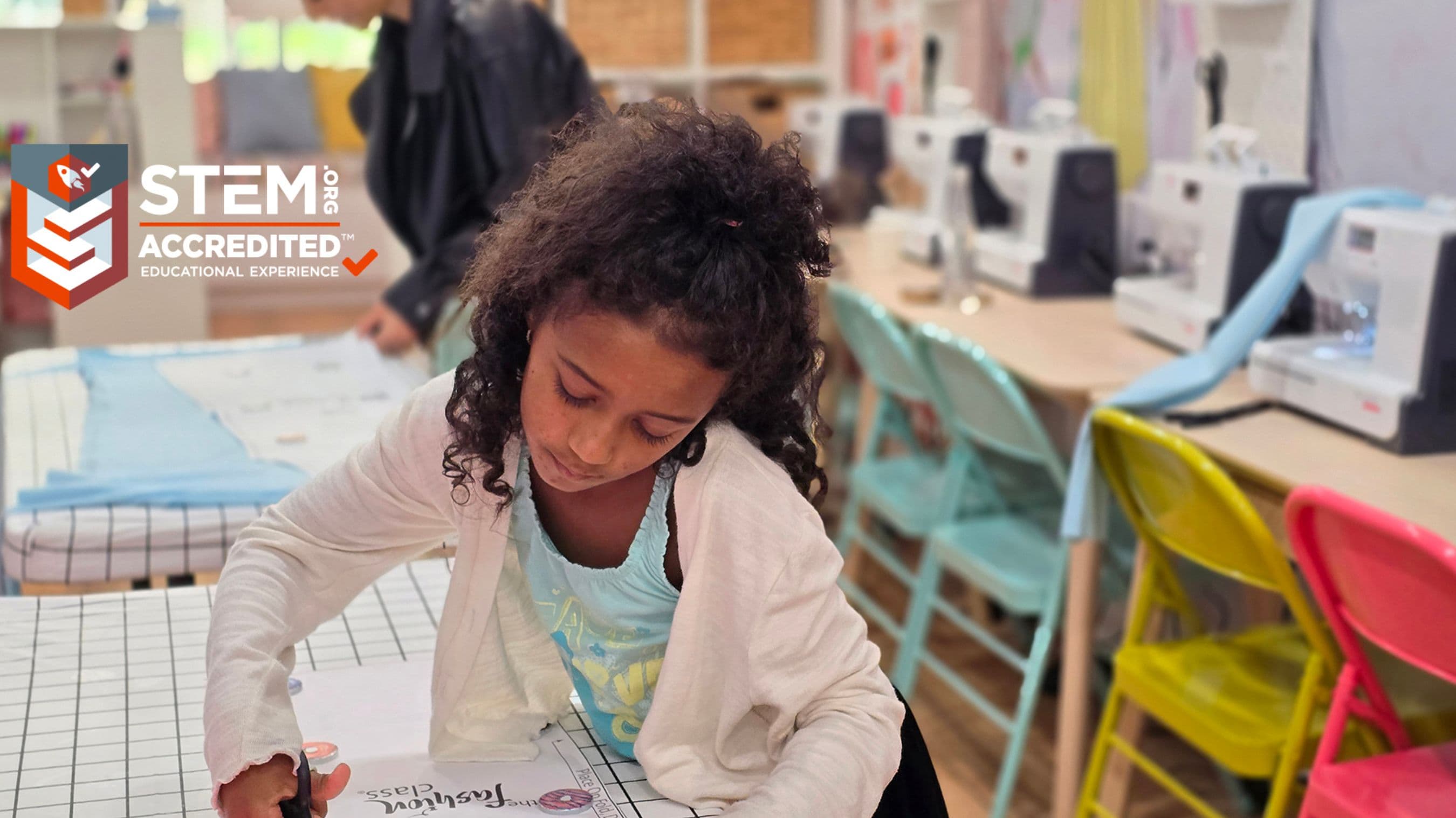 A girl engaged in a STEM-accredited sewing class at The Fashion Class franchise location